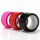 Assorted bondage tape rolls in pink, red, and black featuring a glossy self-adhering finish for restraint play, body wrapping, and creative roleplay scenarios