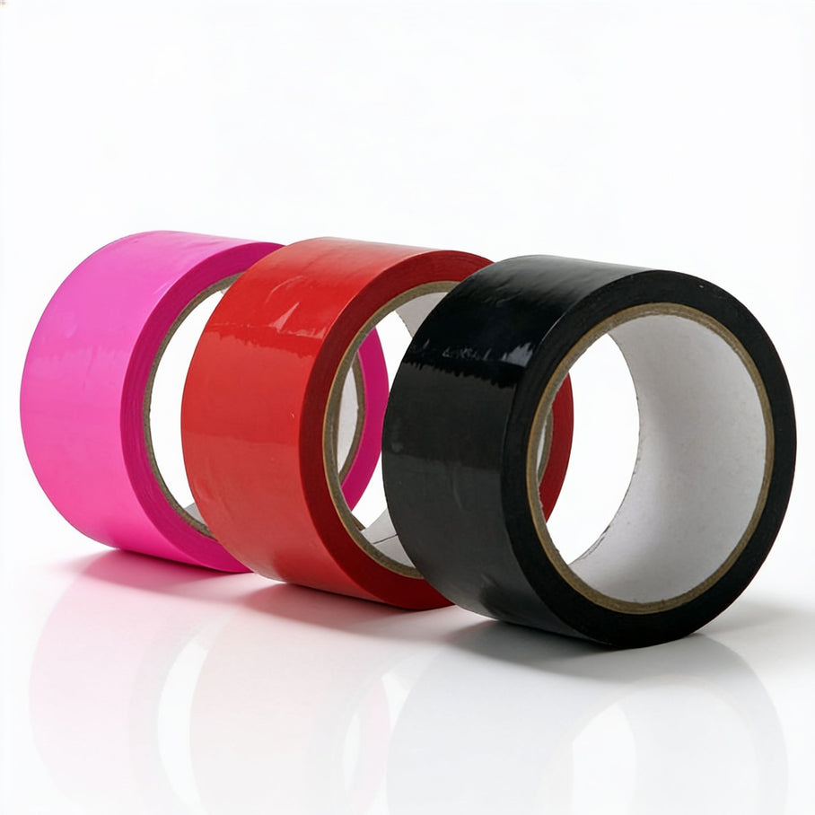 Assorted bondage tape rolls in pink, red, and black featuring a glossy self-adhering finish for restraint play, body wrapping, and creative roleplay scenarios
