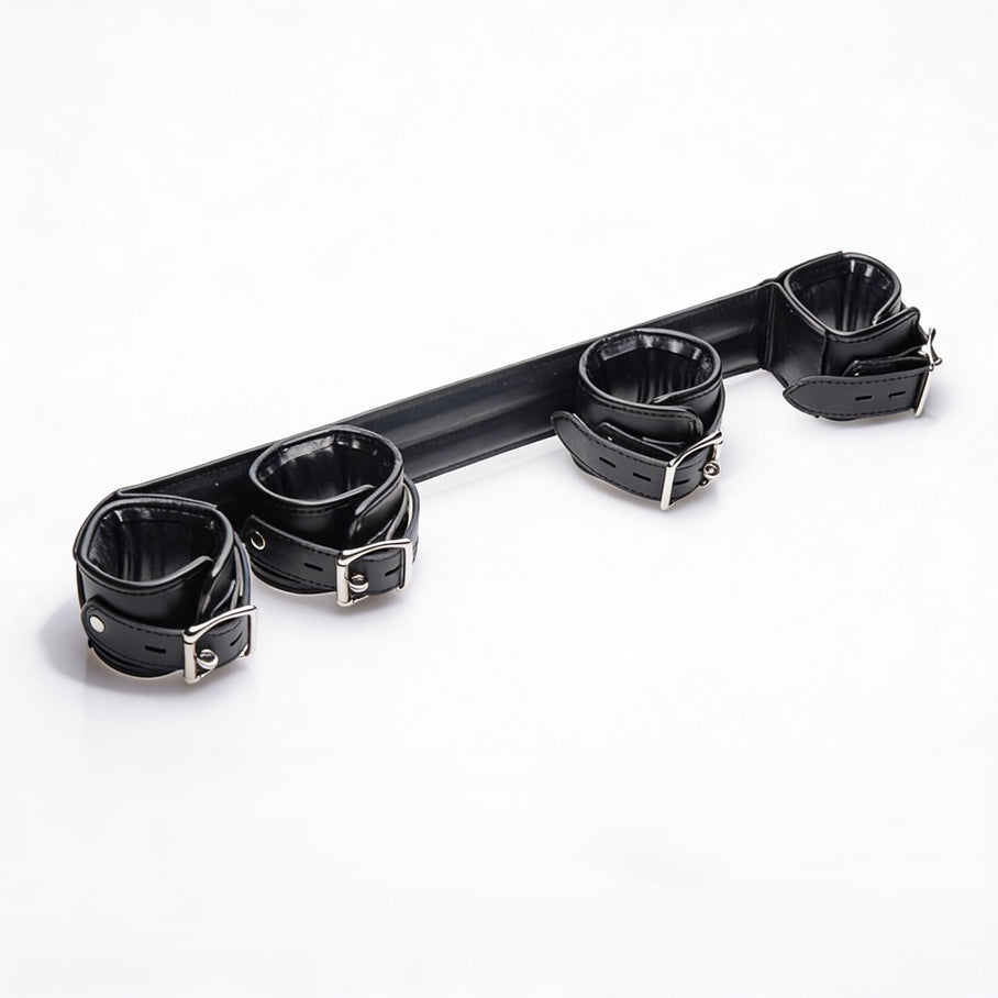Angled view of the Deluxe Rigid Spreader Bar highlighting the four padded faux leather cuffs, rigid support bar, adjustable straps, and metal buckles
