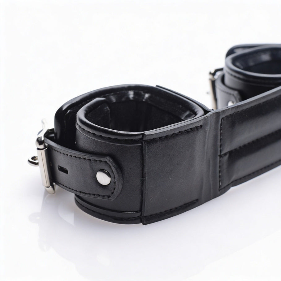 Detailed close-up of an end cuff on the Deluxe Rigid Spreader Bar featuring soft padding, durable faux leather construction, reinforced stitching, and adjustable buckle hardware