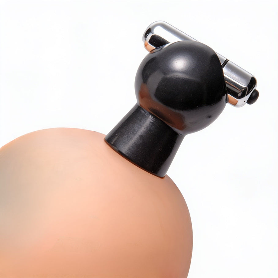 Close-up of a vibrating nipple sucker attached to a breast, highlighting the suction cup design and chrome vibrating stimulation bar