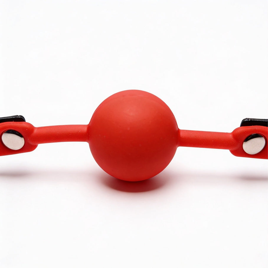 close-up of smooth red silicone ball on adjustable comfort ball gag with black strap